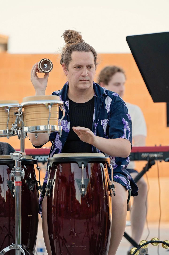 Ro Webb, a percussionist, playing caxixi, congas and tambourine